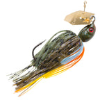 Chatterbait fishing lure with dark green skirt and orange highlights, blue-green head with red eye.