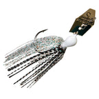 Black-and-white chatterbait lure with white skirt and speckled strands, gold blade